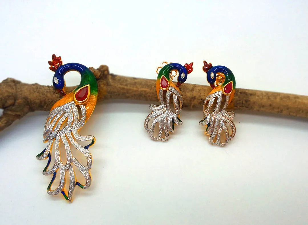Pendant and earrings of enamel peacocks with diamond-set pear tails, resting on a branch