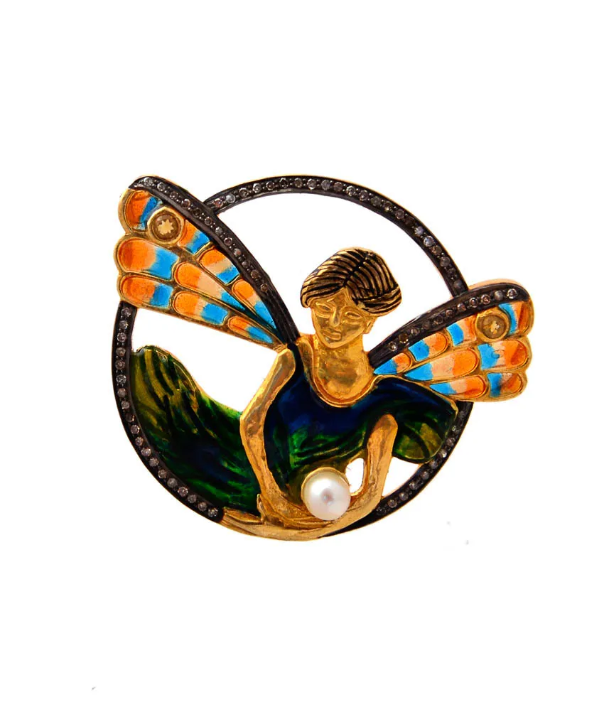 Circular pendant of a reclining fairy with turquoise and orange butterfly wings and a pearl