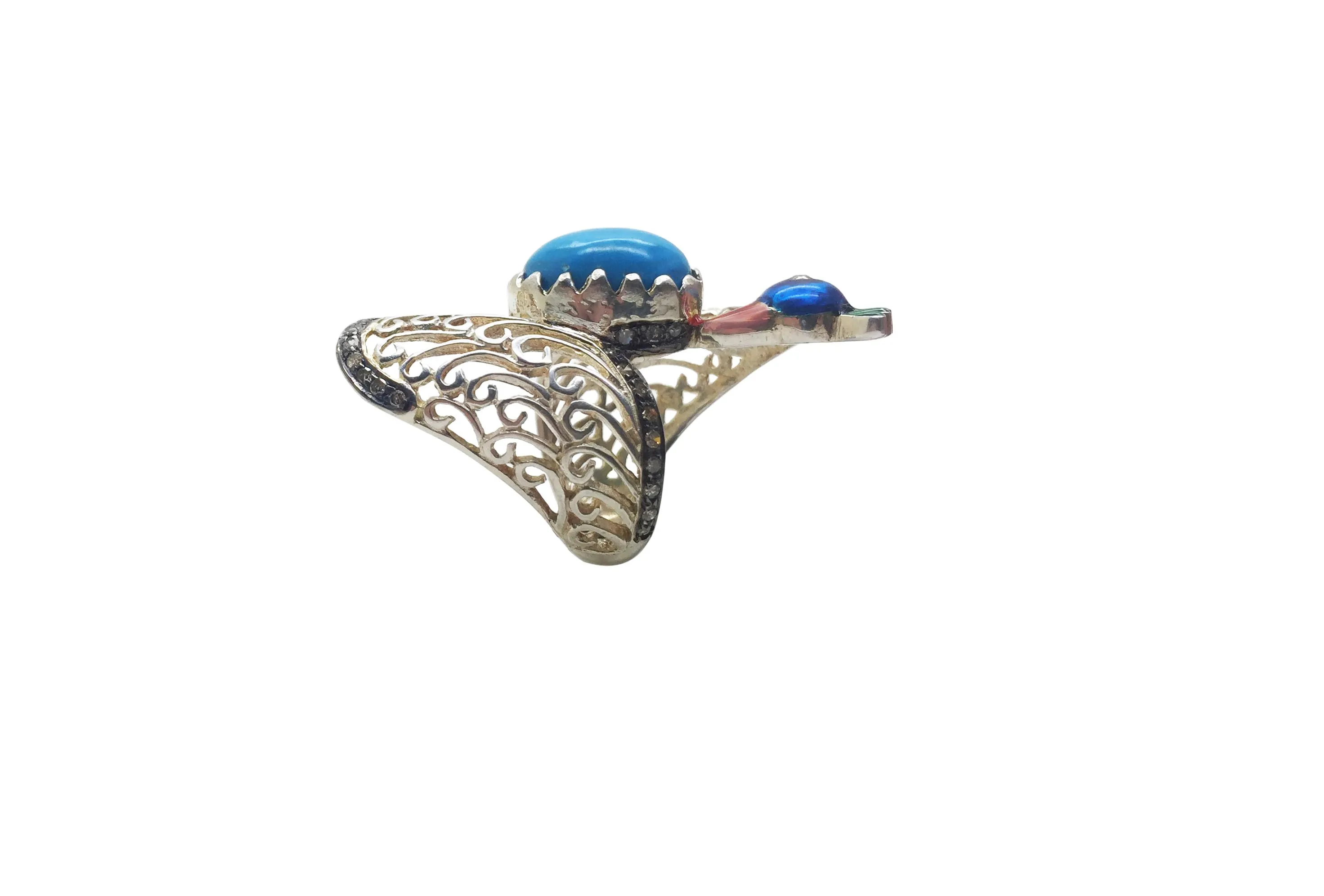 Turquoise peacock ring lying on its side: an oval turquoise cabochon in filigree wings with an enamel peacock head