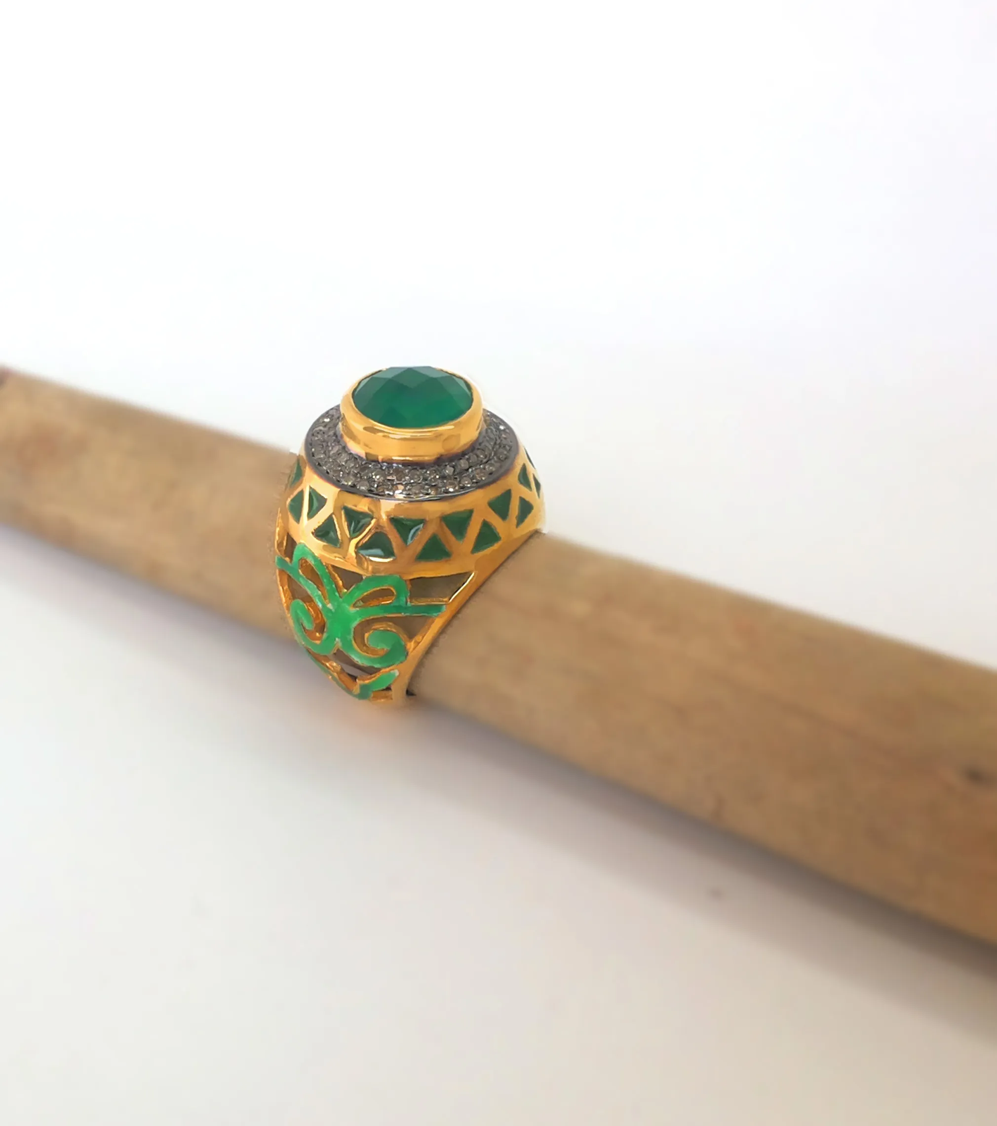 Green lattice ring on a wooden branch, seen from the side